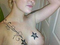 Blondine mit vielen Tattoos fotografiert sich nackt