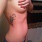 Blondes M�dchen mit Nippelpiercing und Tattoo